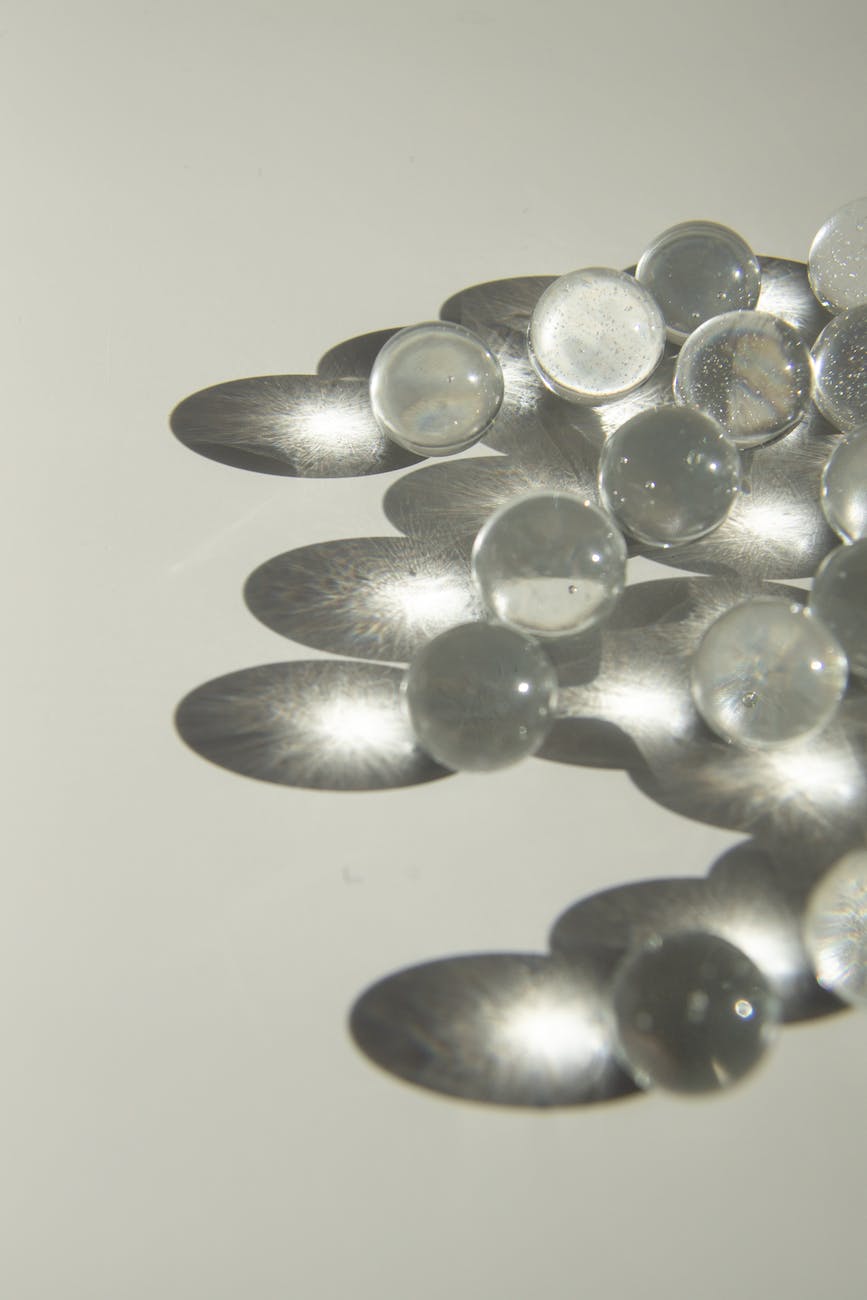 small fragile glass balls with shadows on white table in daylight